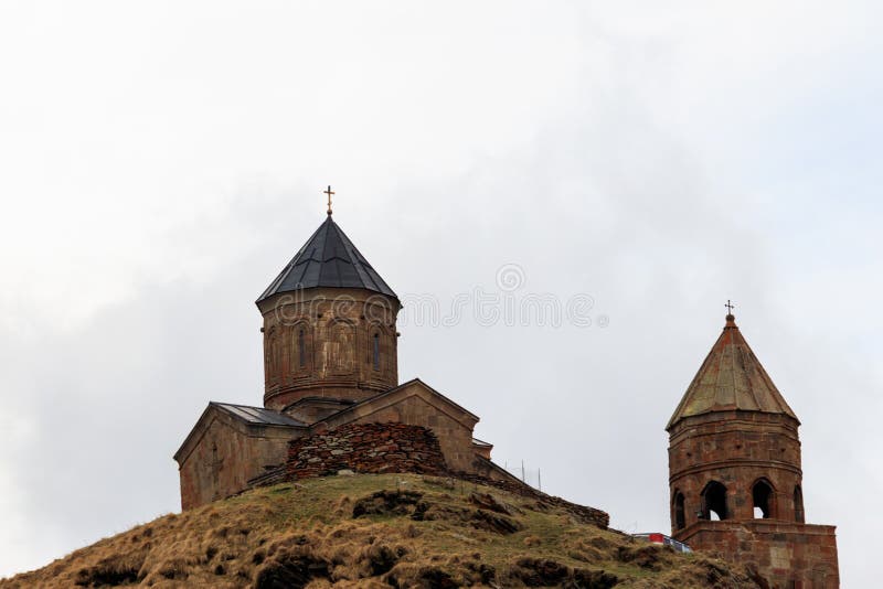 Chiesa di trinità di Gergeti Tsminda Sameba, chiesa di trinità santa vicino al villaggio di Gergeti in montagne caucasiche, Georg fotografia stock libera da diritti Chiesa di trinità di Gergeti Tsminda Sameba, chiesa di trinità santa vicino al villaggio di Gergeti in montagne caucasiche, Georg fotografia stock libera da diritti