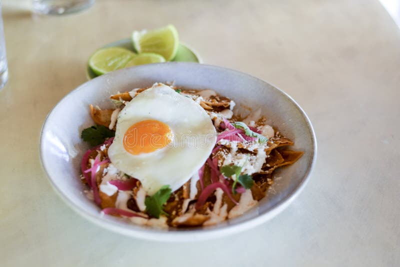 Chilaquiles messicani del piatto della prima colazione fotografia stock libera da diritti Chilaquiles messicani del piatto della prima colazione fotografia stock libera da diritti