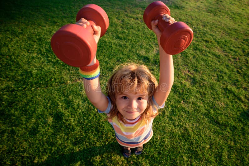 Child Activity. Funny Sport. Kid with Dumbbells. Wide Angle. Stock