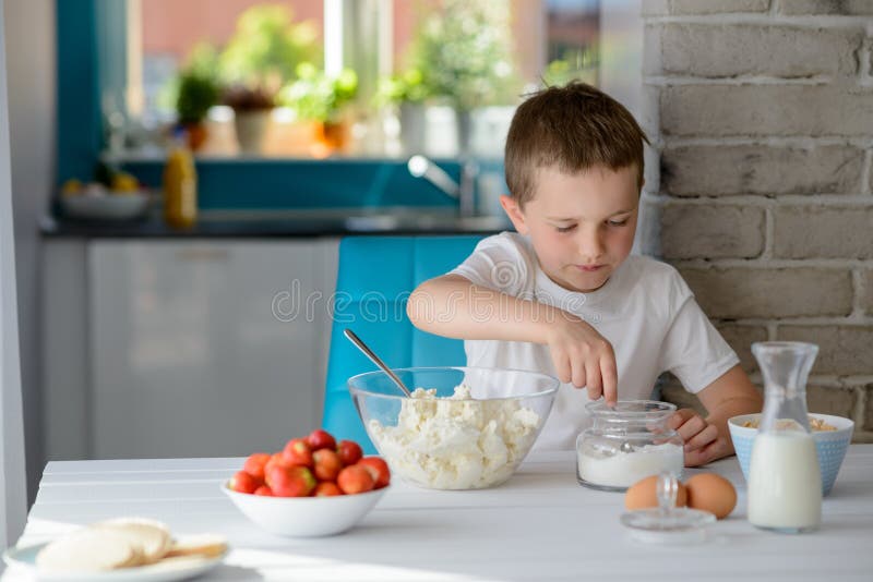 Child adding sugar to cottage cheese in a bowl. royalty free stock image