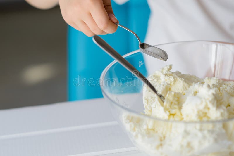 Child adding sugar to cottage cheese in a bowl. royalty free stock photo