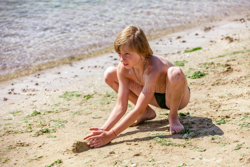 Child on a beach being played sand