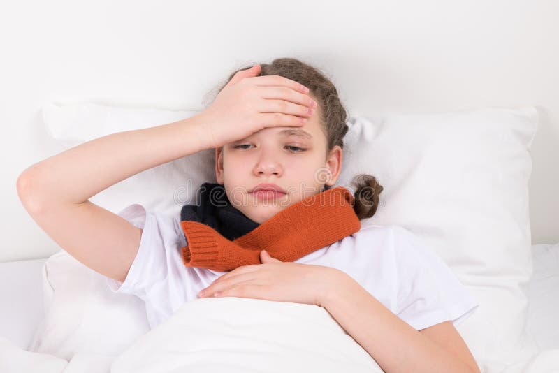 Child in bed holds a hand on his forehead reducing royalty free stock photography Child in bed holds a hand on his forehead reducing royalty free stock photography