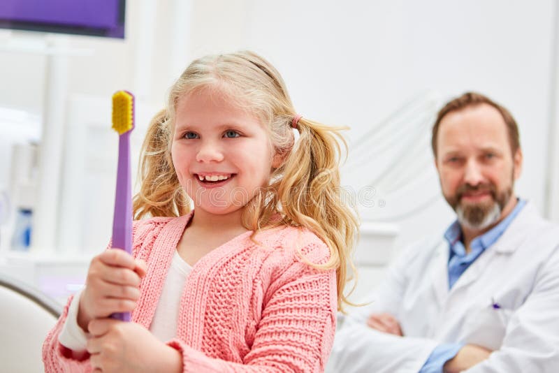 Child with a big toothbrush learns dental care royalty free stock photos Child with a big toothbrush learns dental care royalty free stock photos