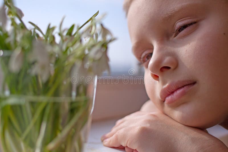 Child boy close up looking at snowdrops stock image Child boy close up looking at snowdrops stock image