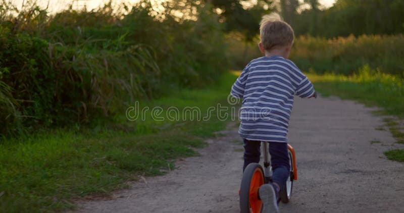 A Child Boy Rides Balance Bike in a City Park Stock Video - Video of ...