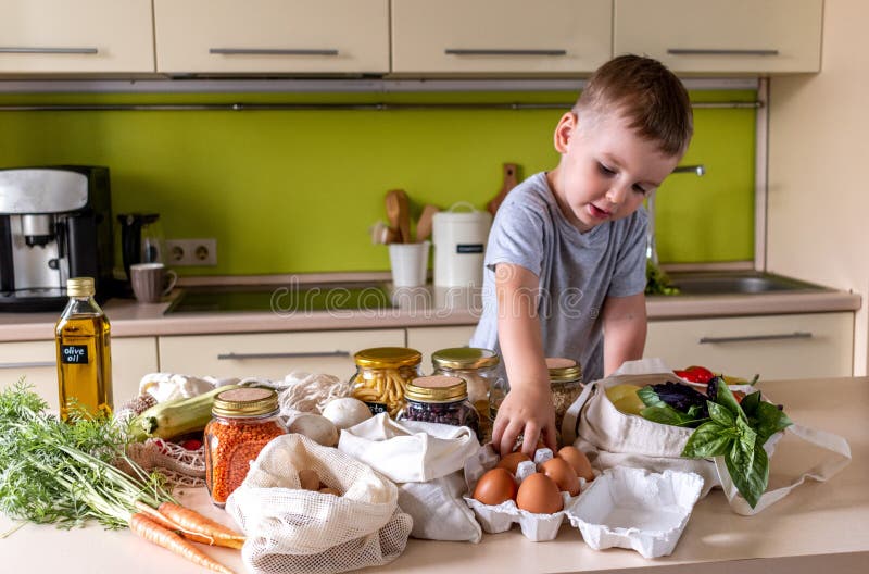 Child Boy Stands in the Kitchen and Reaches Out with His Hand for a ...