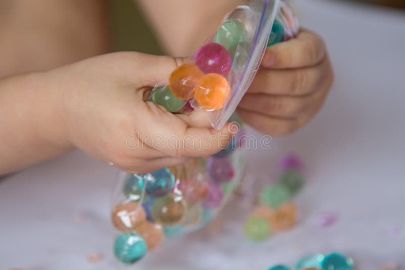 Child breaking the hydrogel beads in a plastic zip package royalty free stock photos Child breaking the hydrogel beads in a plastic zip package royalty free stock photos