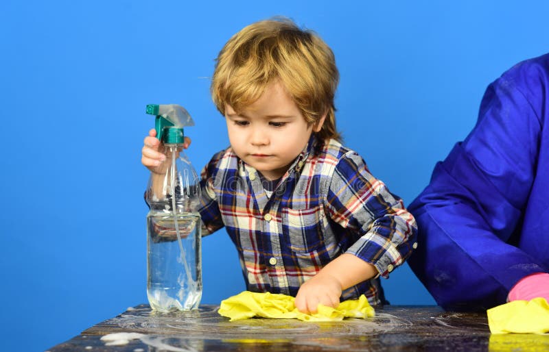 Kid Wiping Table With Yellow Rag And Holds Spray. Stock Photo - Image ...