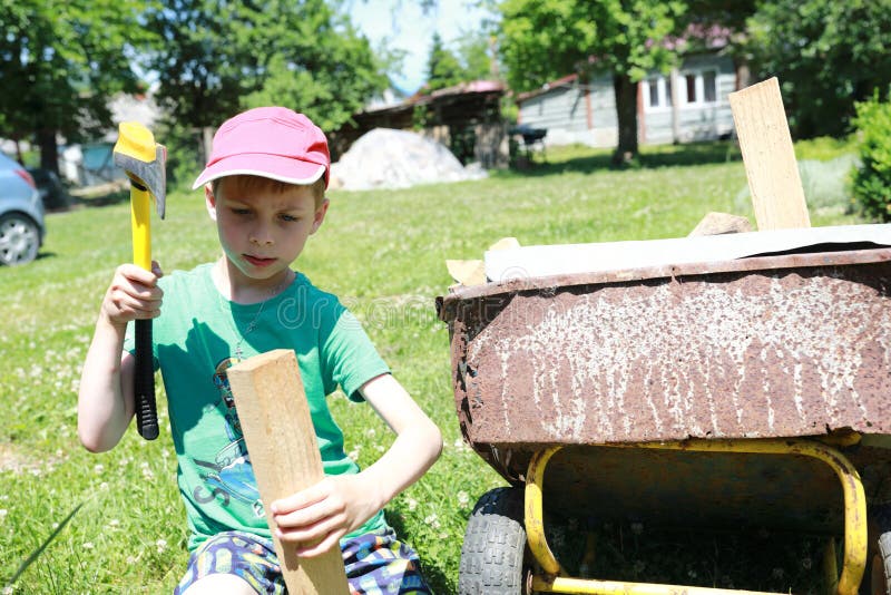 Child chopping wood with ax royalty free stock photos