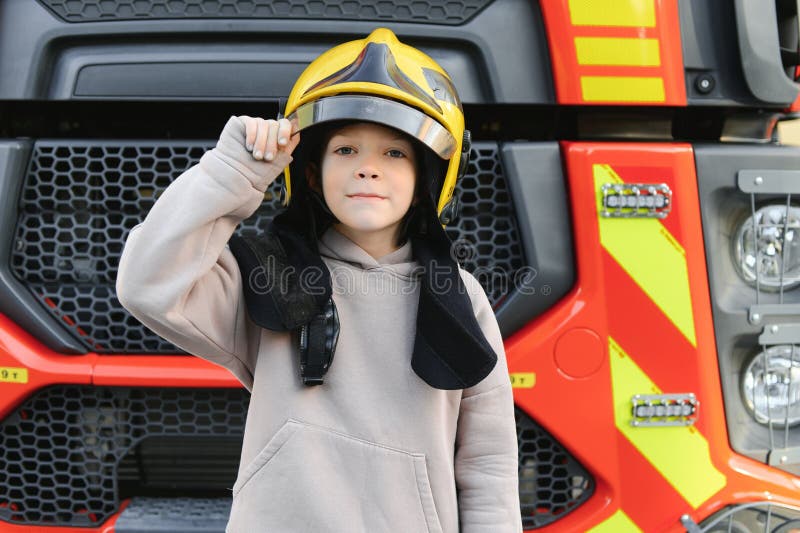Child, Cute Boy, Dressed in Fire Fighers Cloths in a Fire Station with
