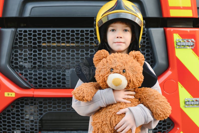 Child, Cute Boy, Dressed in Fire Fighers Cloths in a Fire Station with