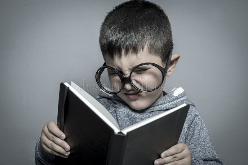 Child, dark-haired young student reading a funny book, reading a