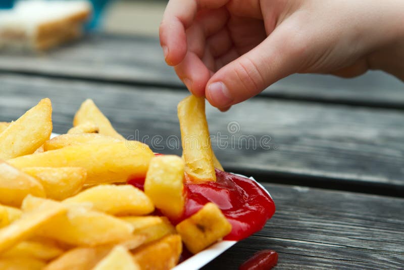 Child Dipping A Chip Into Tomato Sauce Royalty Free Stock Images