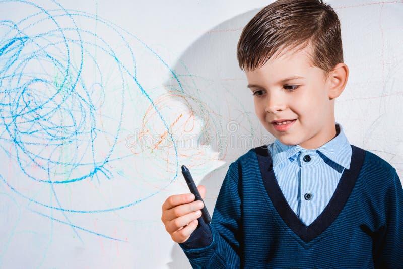 The Child Draws on the Wall with a Crayon. the Boy is Engaged in