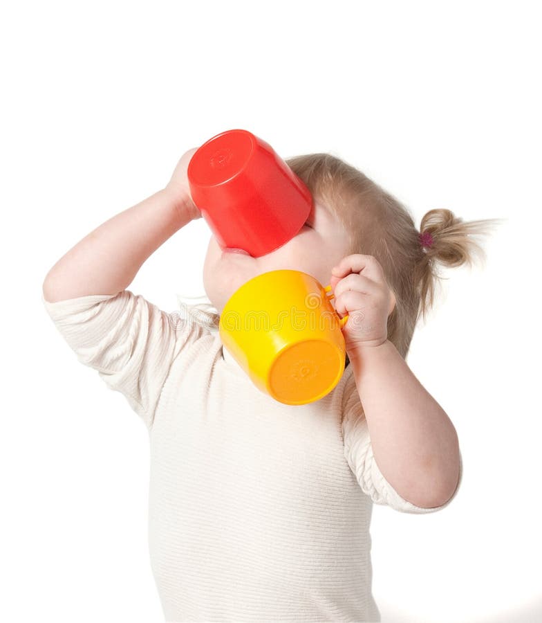 Child drinks juice from a mug.