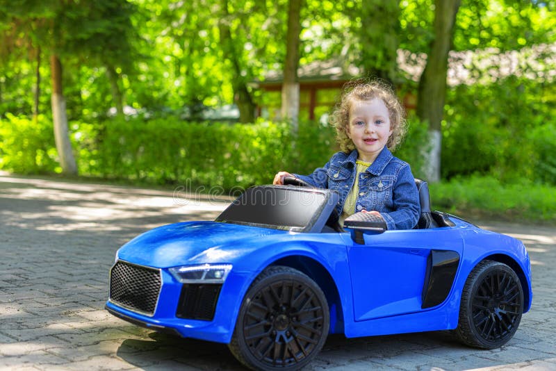 Child is Driving a Toy Car in the Park. Stock Photo Image of tire