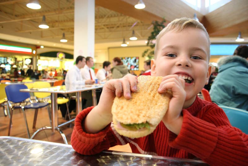 Happy boy child eat burger