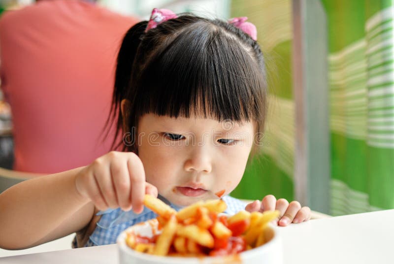 Concentrate on the child to eat Fries. Concentrate on the child to eat Fries