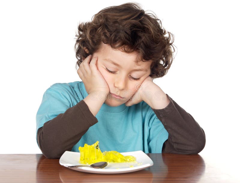 Bambino a mangiare noioso cibo su sfondo bianco.