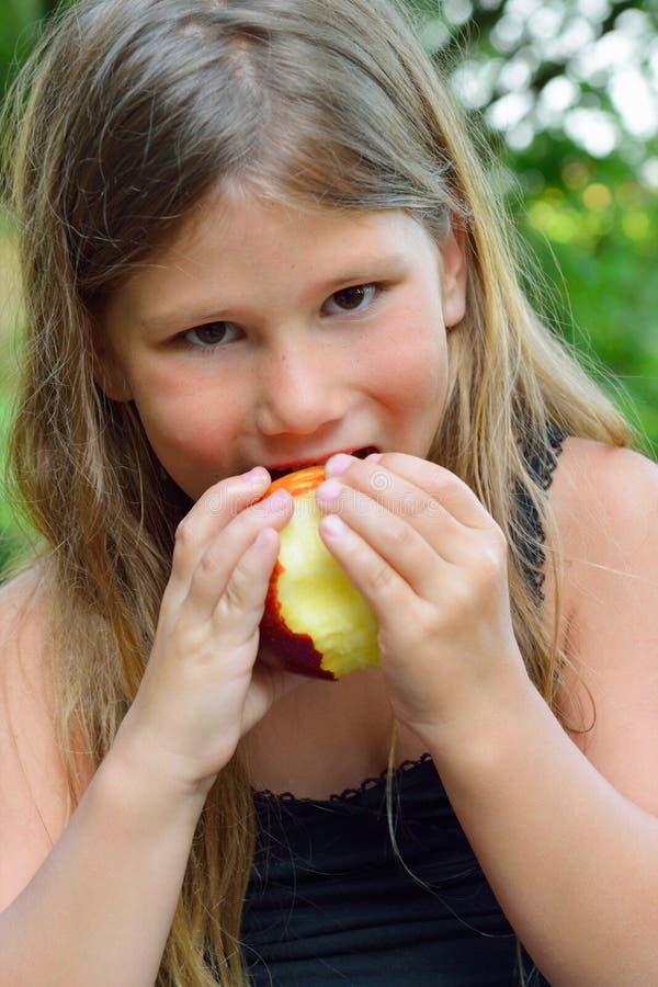 Child eating a red apple stock photo. Image of apple 32719776