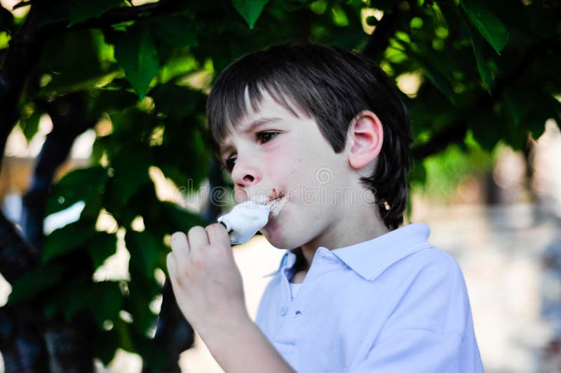 Child eats an ice cream in the shade of a tree royalty free stock photography Child eats an ice cream in the shade of a tree royalty free stock photography