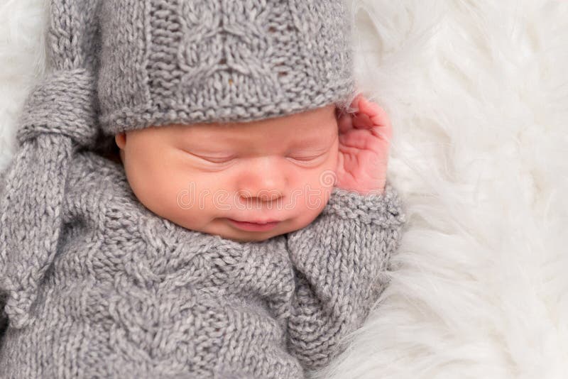 Child enveloped in a gray blanket, closeup