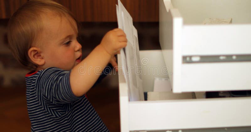 Child exploring open drawers