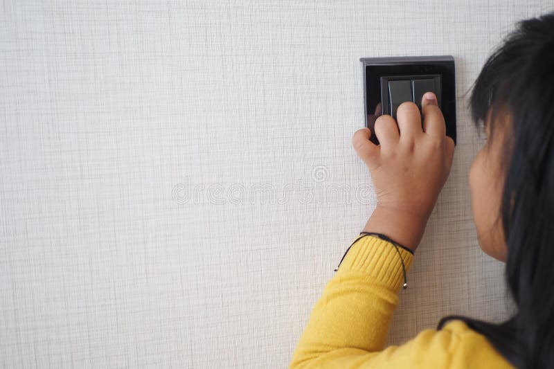 Child finger turning on lighting switch with copyspace royalty free stock image