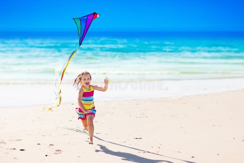 Child flying kite on tropical beach