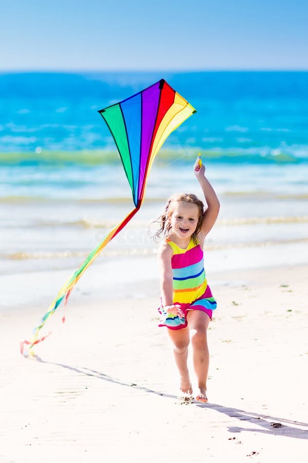 Child flying kite on tropical beach