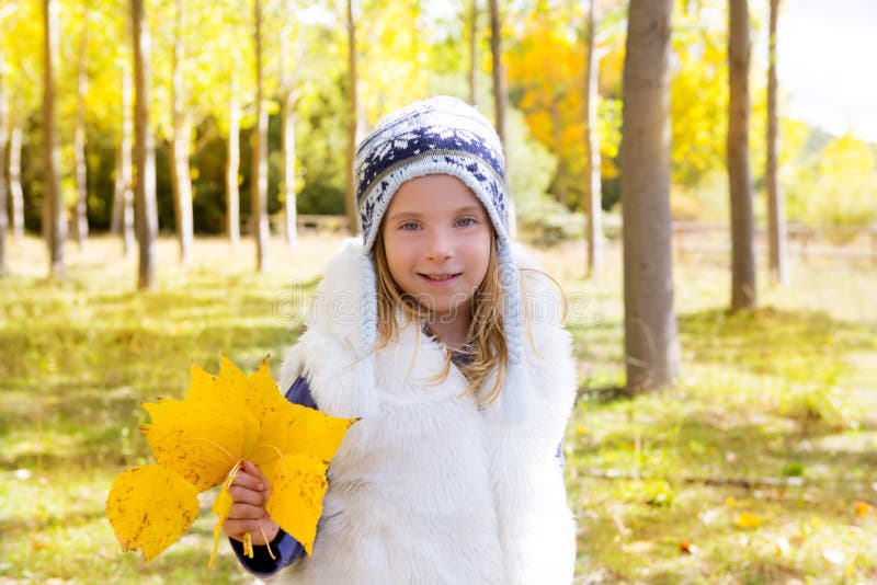 Child girl in autumn poplar forest yellow fall leaves in hand