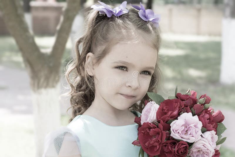 Child girl with bouquet of roses. Tender portrait