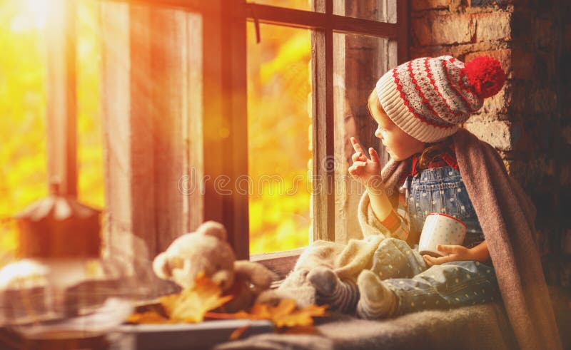 Child girl with cup tea looking through window at nature autumn royalty free stock image Child girl with cup tea looking through window at nature autumn royalty free stock image