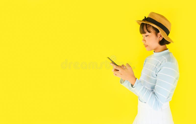 Child girl hands holding smartphone on yellow background - Asian young woman using mobile phone fashion pretty in the summer and royalty free stock images Child girl hands holding smartphone on yellow background - Asian young woman using mobile phone fashion pretty in the summer and royalty free stock images