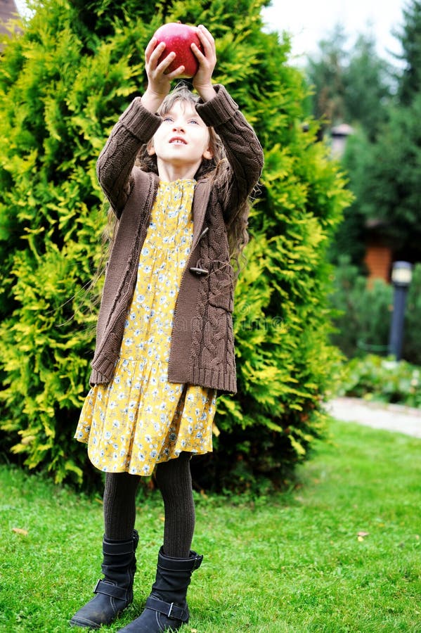 Child girl holding big apple