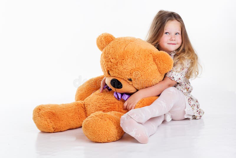 Child girl is hugging her teddy bear