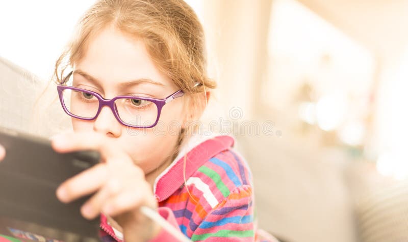 Child girl kid playing game on mobile phone at home