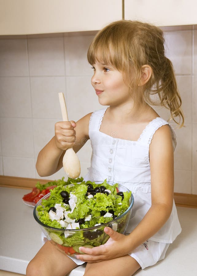 Child girl preparing salad