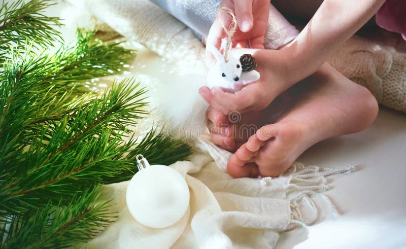 Child girl preparing  winter holidays and Christmas at home. She sitting on floor and playing with Christmas toys. Happy New Year