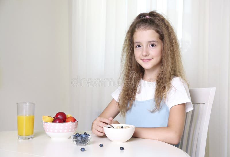 Child girl sitting at table and have a meal.Healthy nutrition concept.Morning breakfast.Young girl eating