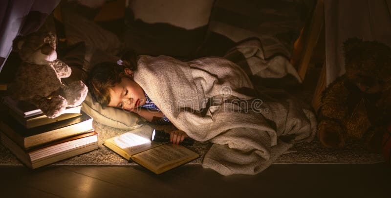 Child girl sleeping in tent with book and flashlight royalty free stock images Child girl sleeping in tent with book and flashlight royalty free stock images
