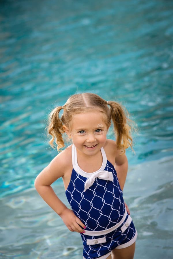 Young female child in blue swim suit standing in pool water. Young female child in blue swim suit standing in pool water