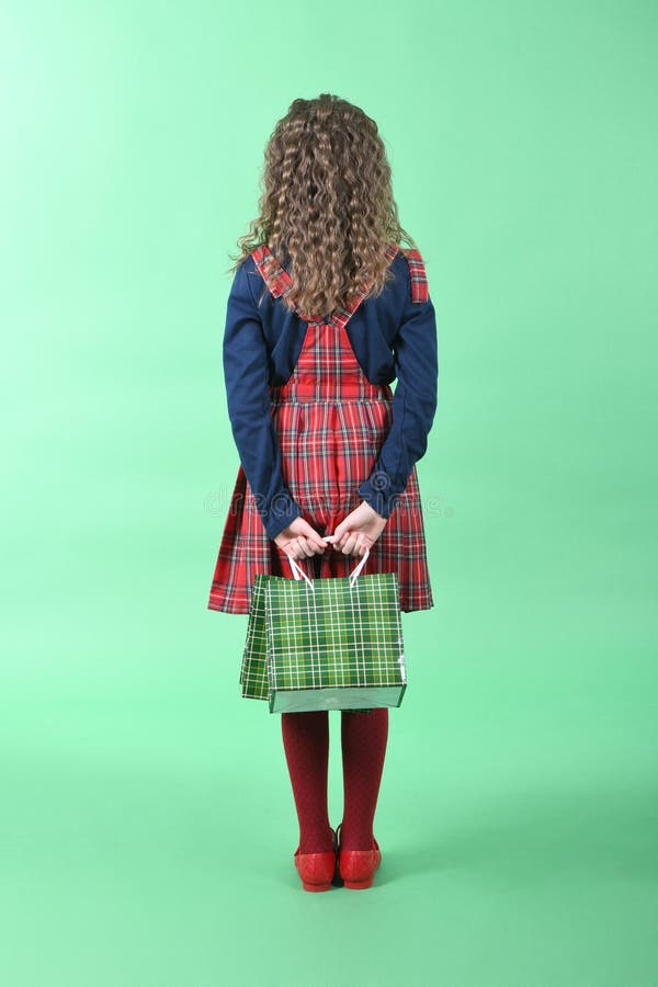 Child with a green packaging checkered texture isolated on green background. Girl likes shopping on sale season. Holiday present, royalty free stock photo Child with a green packaging checkered texture isolated on green background. Girl likes shopping on sale season. Holiday present, royalty free stock photo