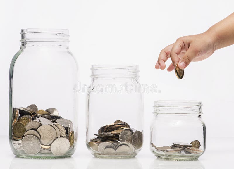 Child hand putting a coin into glass bottle, future saving concept