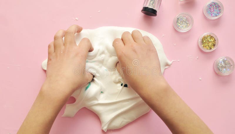 White Slime in Child Hands on Pink Background. Stock Photo - Image