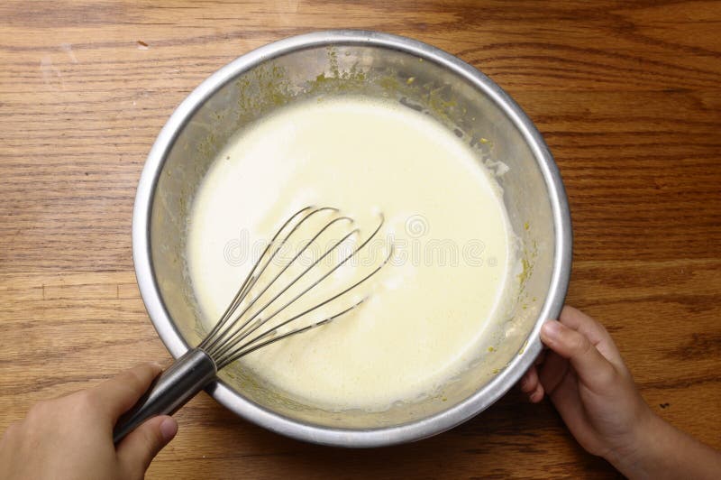 Child hands mixing milk and eggs stock photos