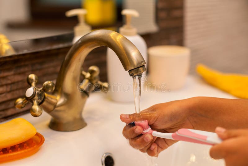 Child hands washing and rinsing a toothbrush royalty free stock photography Child hands washing and rinsing a toothbrush royalty free stock photography