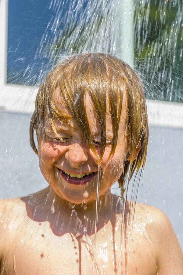 Child has a refreshing shower in the heat