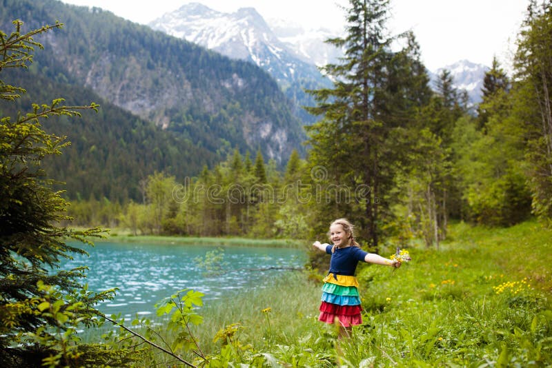 Child hiking in flower field at mountain lake royalty free stock photography Child hiking in flower field at mountain lake royalty free stock photography